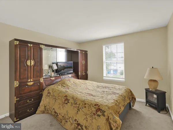 a spacious bedroom with a bed and wooden floor