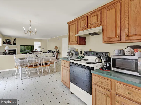 a kitchen with stainless steel appliances granite countertop a stove top oven a sink a dining table and chairs