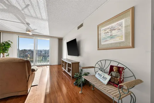 a living room with furniture a flat screen tv and a floor to ceiling window