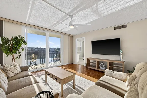 a living room with furniture a flat screen tv and a large window