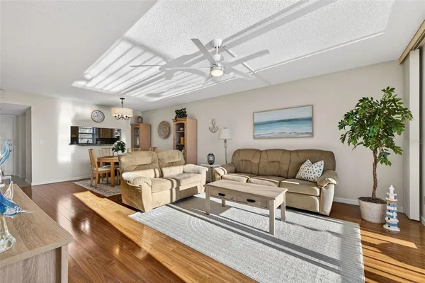 a living room with furniture a chandelier and a flat screen tv