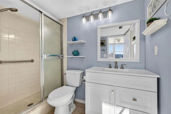 a bathroom with a toilet sink vanity and shower
