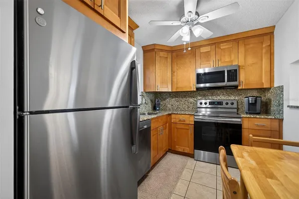 a kitchen with stainless steel appliances granite countertop a refrigerator a stove a sink and dishwasher