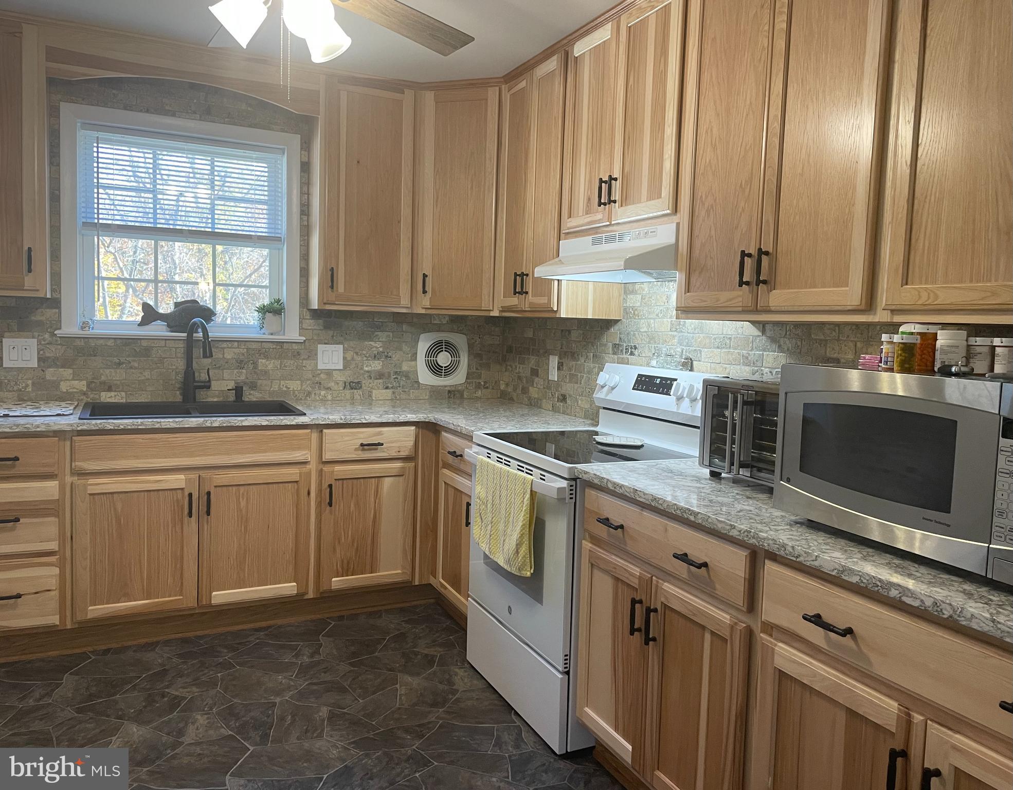 13710 South Springfield Road Brandywine, MD 20613 - Photo 23 of 64 a kitchen with granite countertop white cabinets sink and stainless steel appliances