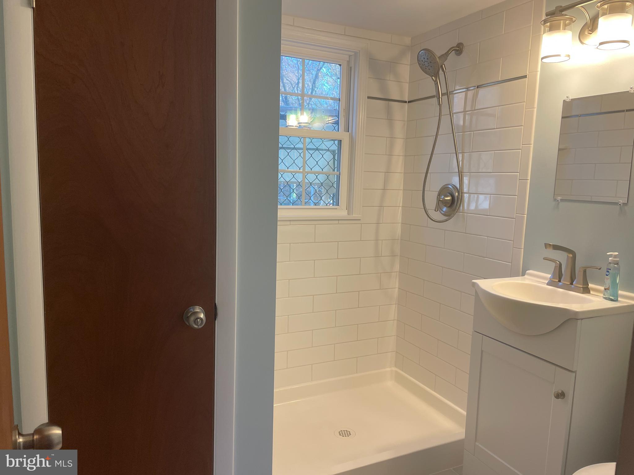 13710 South Springfield Road Brandywine, MD 20613 - Photo 50 of 64 a bathroom with a shower a mirror and a sink