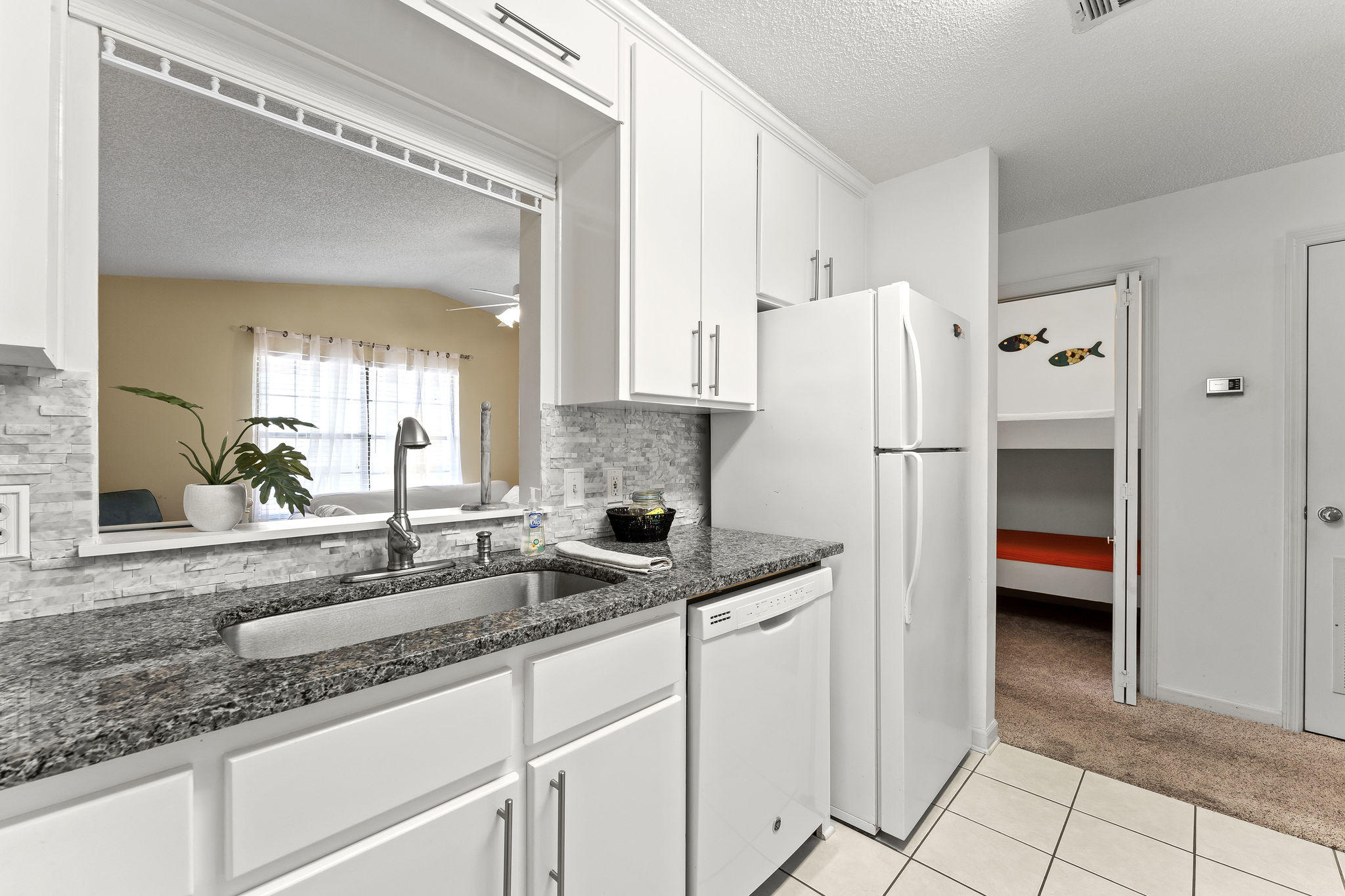 17462 Front Beach Road, Unit 77H Panama City Beach, FL 32413 - Photo 12 of 28 a kitchen with a sink and a refrigerator
