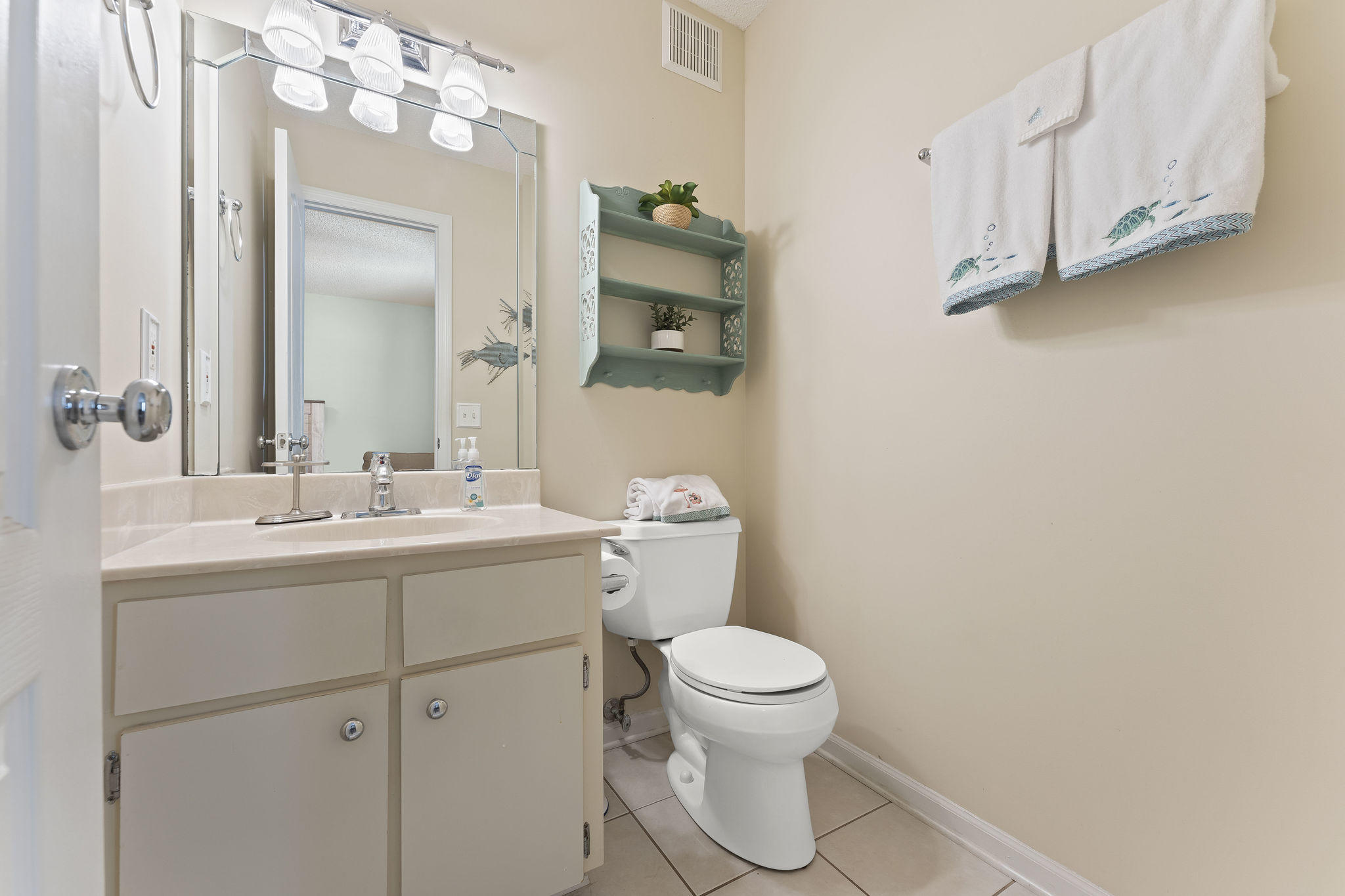17462 Front Beach Road, Unit 77H Panama City Beach, FL 32413 - Photo 16 of 28 a bathroom with a toilet sink and mirror