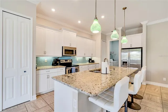 a kitchen with stainless steel appliances granite countertop a sink refrigerator and microwave