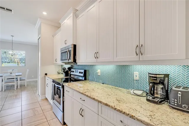 a kitchen with granite countertop a sink a stove and cabinets