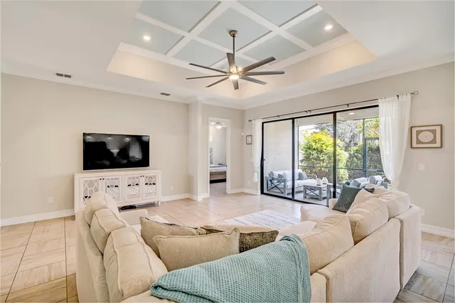 a living room with furniture a flat screen tv and a large window