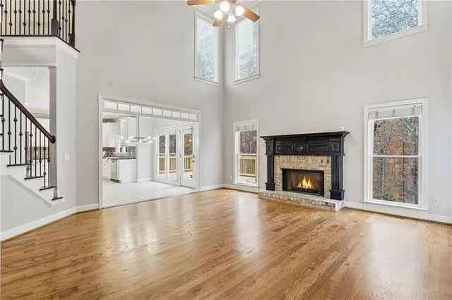 an empty room with a chandelier fan and windows