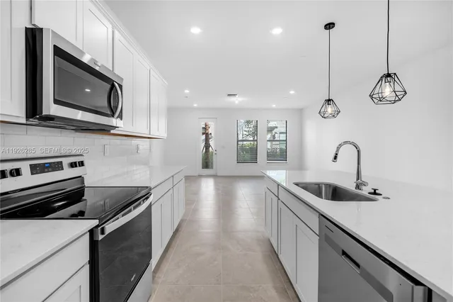 a kitchen with stainless steel appliances granite countertop a sink and microwave