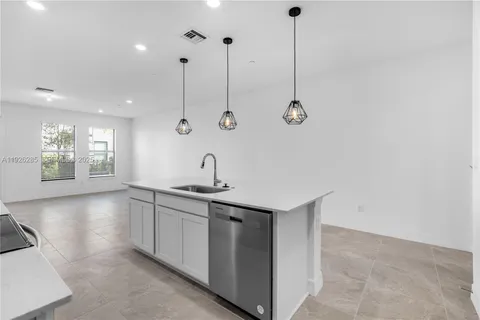 a kitchen with stainless steel appliances granite countertop a sink a window and chairs