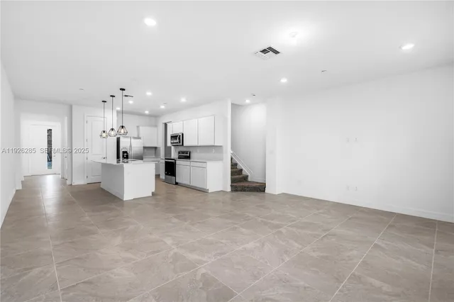 a view of large kitchen with white cabinets