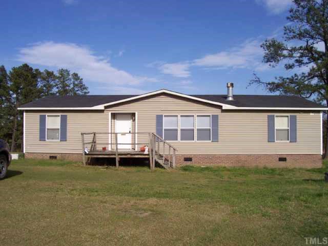2223 Massengill Pond Road Angier, NC 27501 - Photo 1 of 1 a front view of a house with a garden and yard