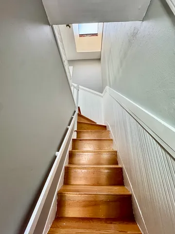 a view of empty room with window and wooden floor