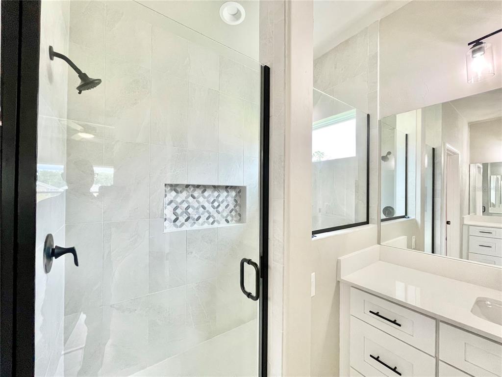1021 Southwest 67th Street Gainesville, FL 32607 - Photo 16 of 53 a bathroom with a shower sink and mirror