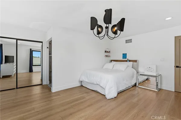 a bedroom with a bed and painting on the wall