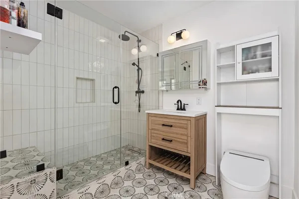 a bathroom with a sink a toilet and shower