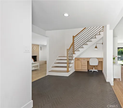 a view of an empty room with stairs and a window