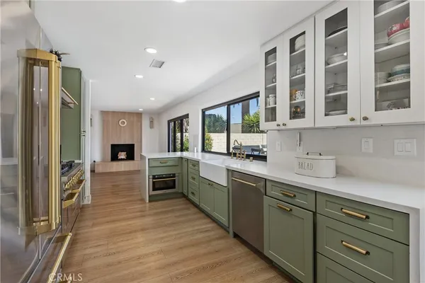 a large kitchen with stainless steel appliances granite countertop a refrigerator and a stove top oven