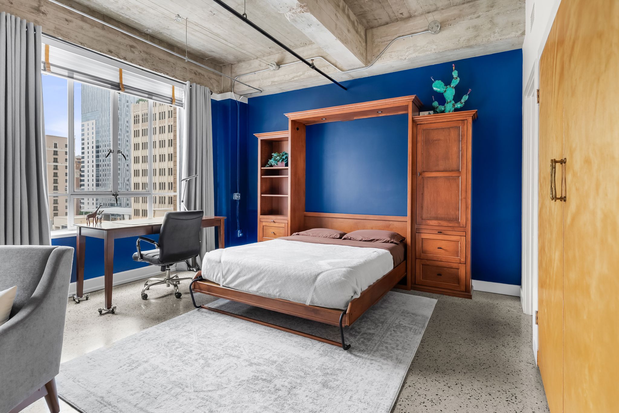 710 Colorado Street, Unit 6E Austin, TX 78701 - Photo 14 of 24 City views frame this innovative living space with built-in bed and convenient work area.