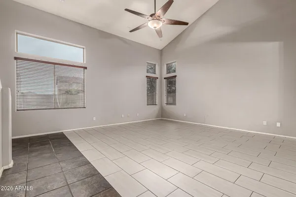 an empty room with windows and ceiling fan