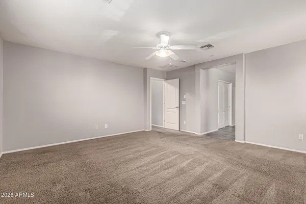 an empty room with a ceiling fan and a fan