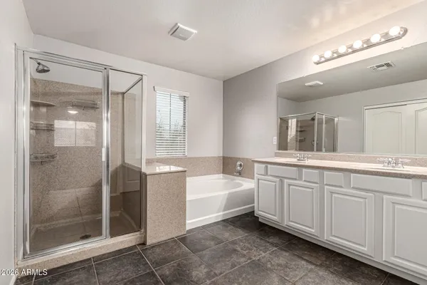 a spacious bathroom with a tub sink shower and mirror