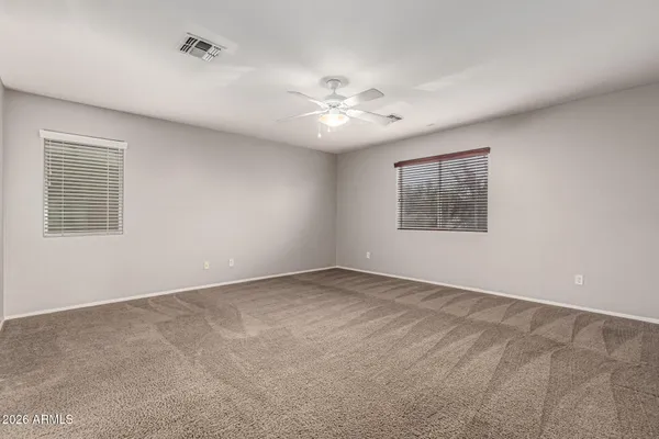 an empty room with a window and a fan