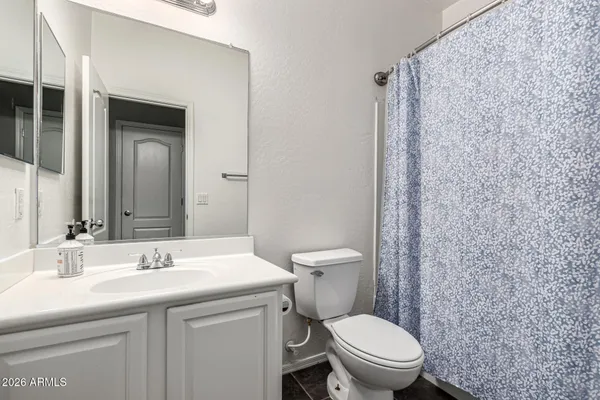a bathroom with a granite countertop toilet sink and a mirror