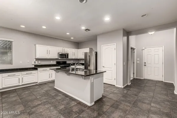 a kitchen with stainless steel appliances granite countertop a refrigerator and a stove top oven