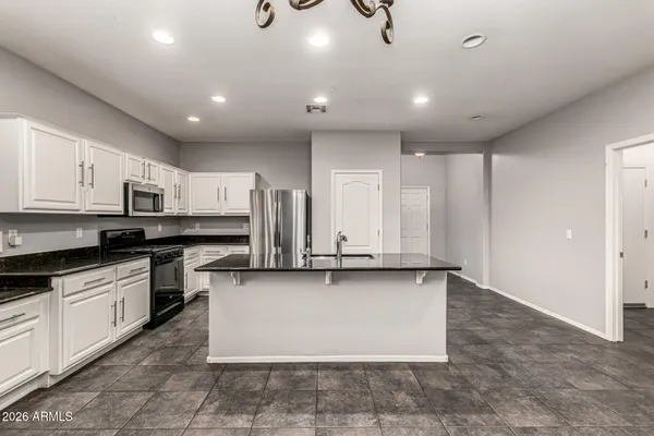a large kitchen with stainless steel appliances granite countertop a stove a sink and a refrigerator