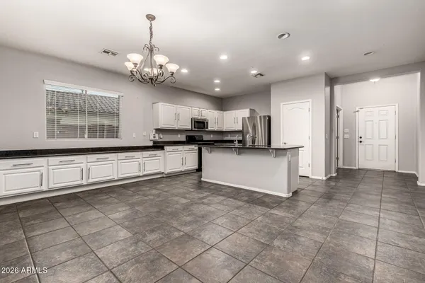 a large kitchen with granite countertop a stove a sink a microwave and cabinets