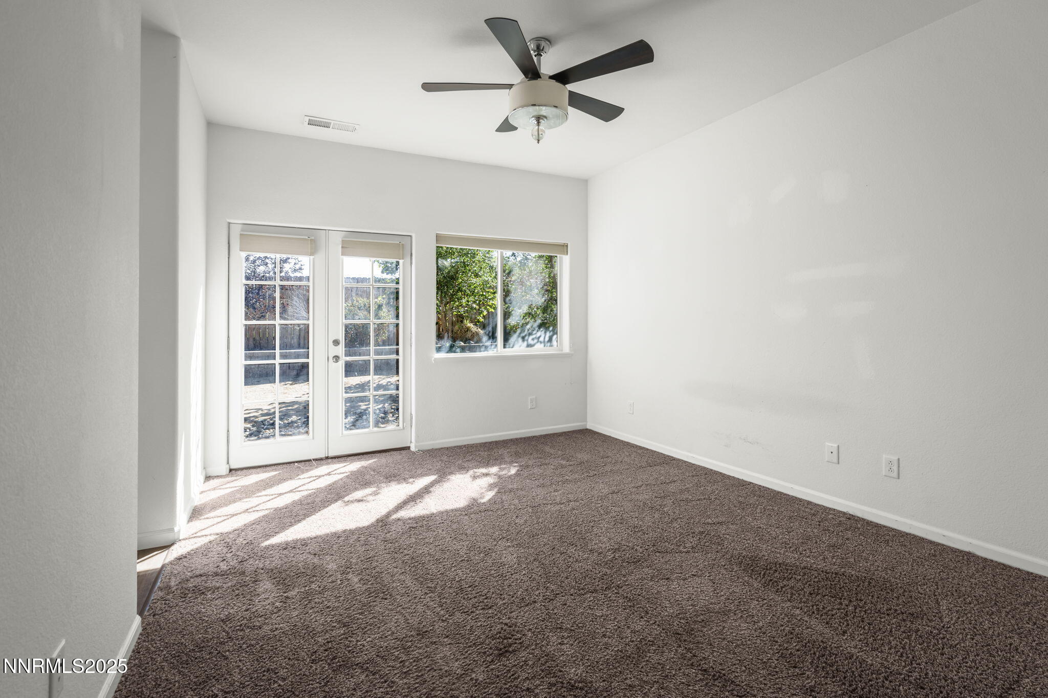 1187 Jasmine Lane Fernley, NV 89408 - Photo 13 of 22 an empty room with windows and ceiling fan