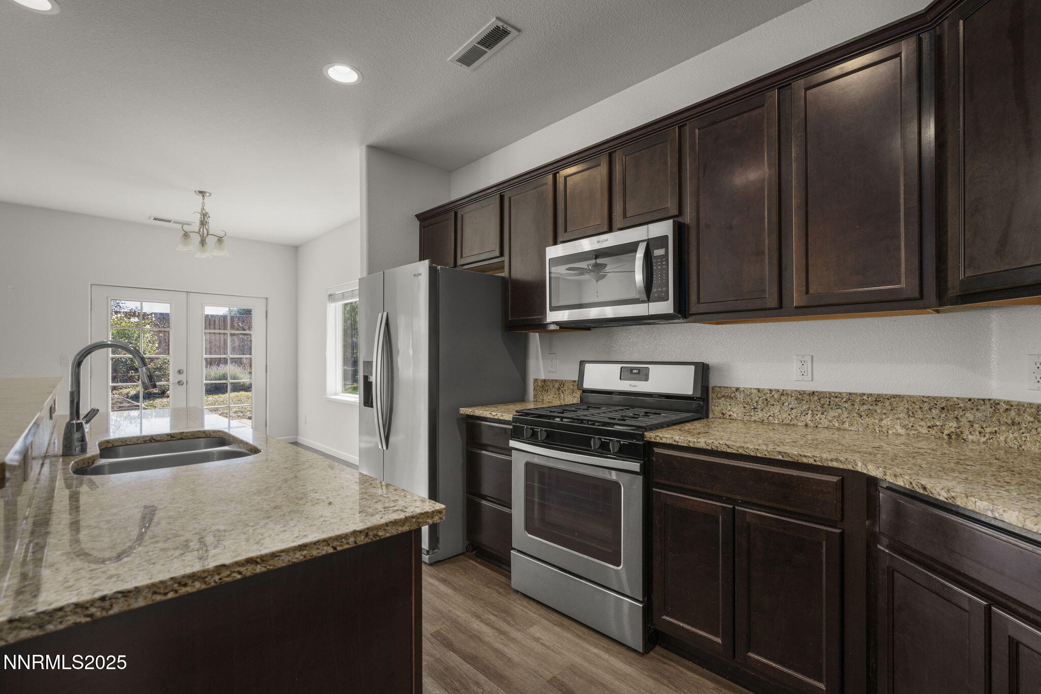 1187 Jasmine Lane Fernley, NV 89408 - Photo 3 of 22 a kitchen with granite countertop wooden cabinets and stainless steel appliances