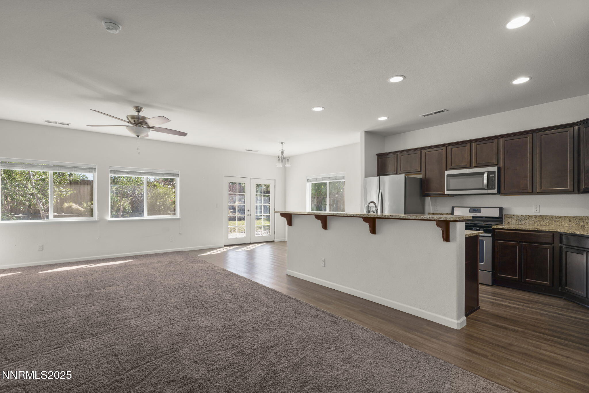 1187 Jasmine Lane Fernley, NV 89408 - Photo 5 of 22 a view of kitchen with microwave a stove and wooden cabinets