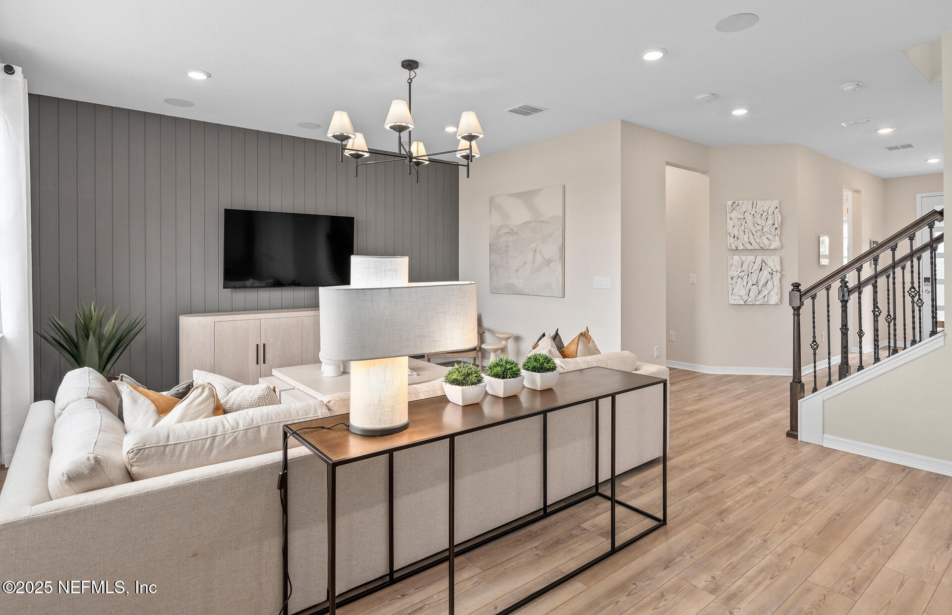 488 Peppervine Way Yulee, FL 32097 - Photo 11 of 17 a living room with furniture a flat screen tv and a chandelier