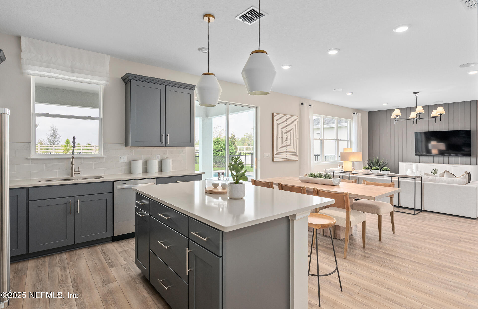 488 Peppervine Way Yulee, FL 32097 - Photo 8 of 17 a kitchen with a stove a sink a dining table and chairs