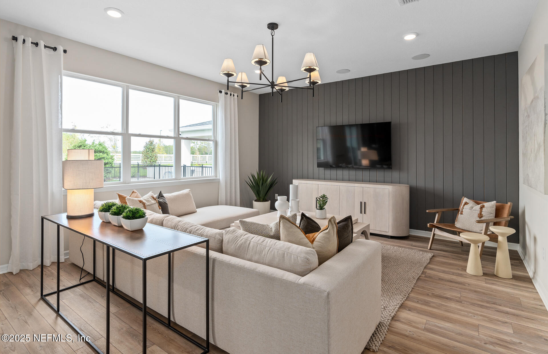 488 Peppervine Way Yulee, FL 32097 - Photo 10 of 17 a living room with furniture a flat screen tv and a large window