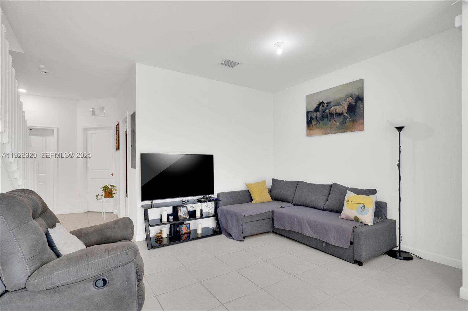 16266 Southwest 291st Street Homestead, FL 33033 - Photo 11 of 34 a living room with furniture and a flat screen tv