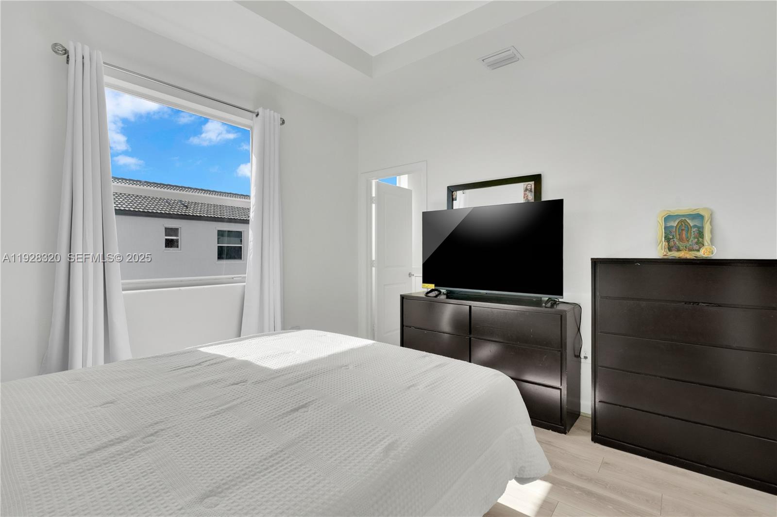 16266 Southwest 291st Street Homestead, FL 33033 - Photo 15 of 34 a bedroom with a bed and a flat screen tv