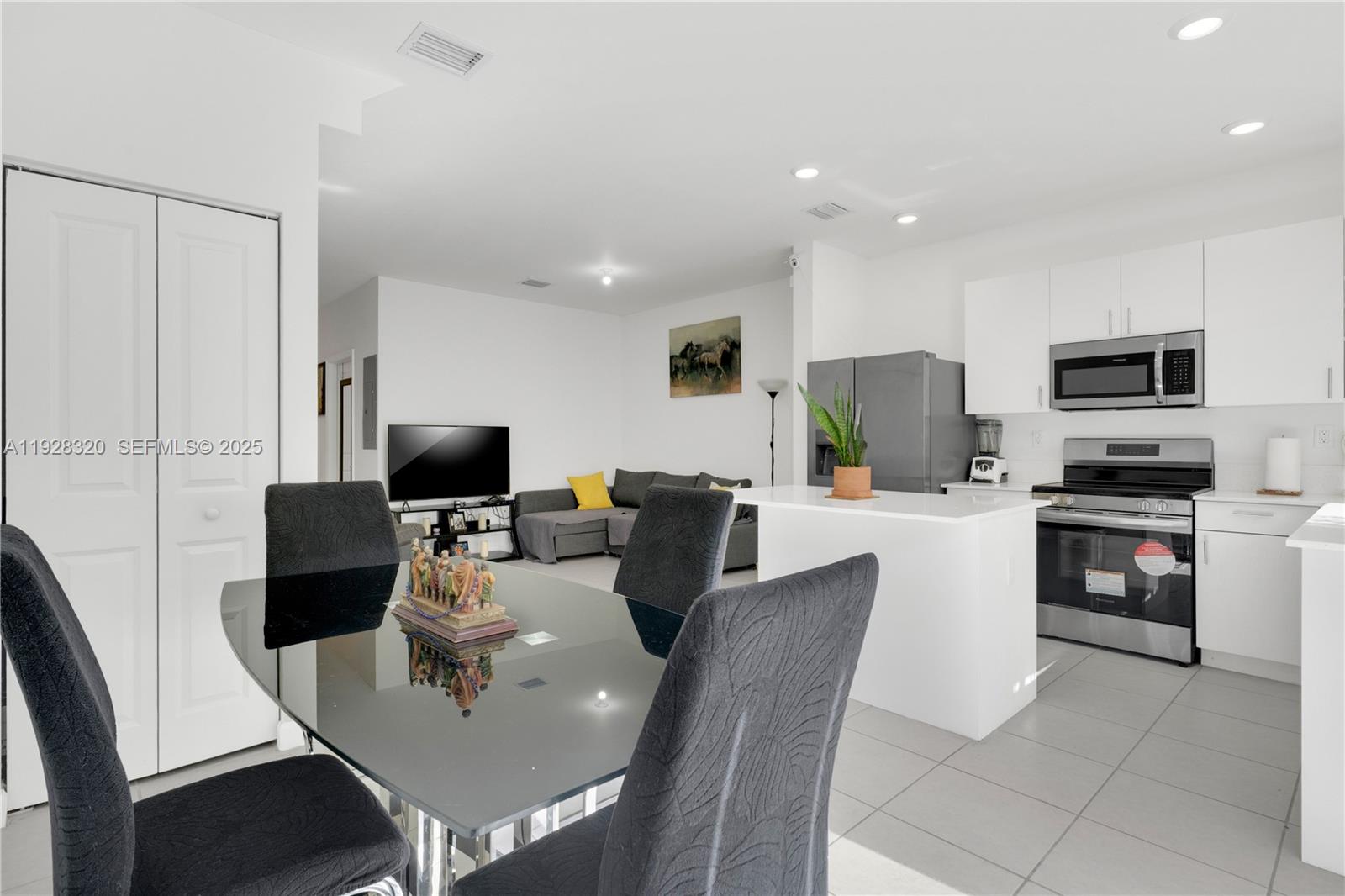 16266 Southwest 291st Street Homestead, FL 33033 - Photo 10 of 34 a living room with stainless steel appliances a dining table wooden floor and a view of kitchen