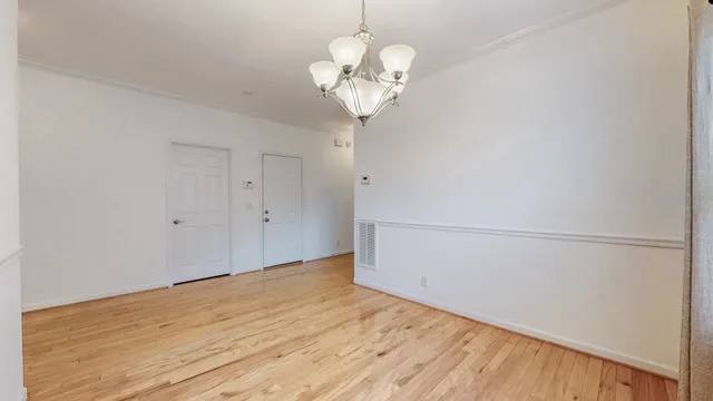 a view of a room with wooden floor and chandelier