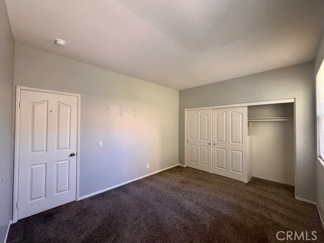 a large kitchen with stainless steel appliances kitchen island granite countertop a stove a sink a refrigerator and white cabinets with wooden floor