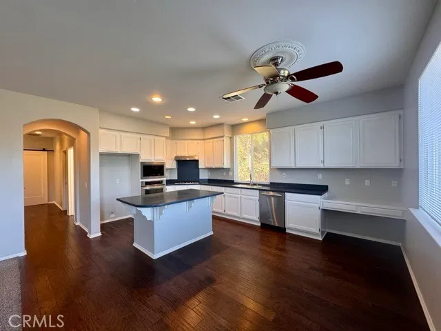 a large kitchen with kitchen island a large counter top space appliances and cabinets