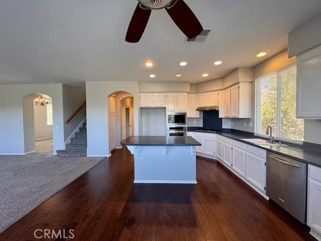 a kitchen with granite countertop a stove a sink and a microwave