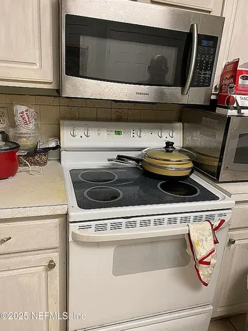 a stove top oven sitting inside of a kitchen