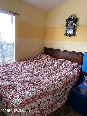 a bed sitting in a bedroom next to a window