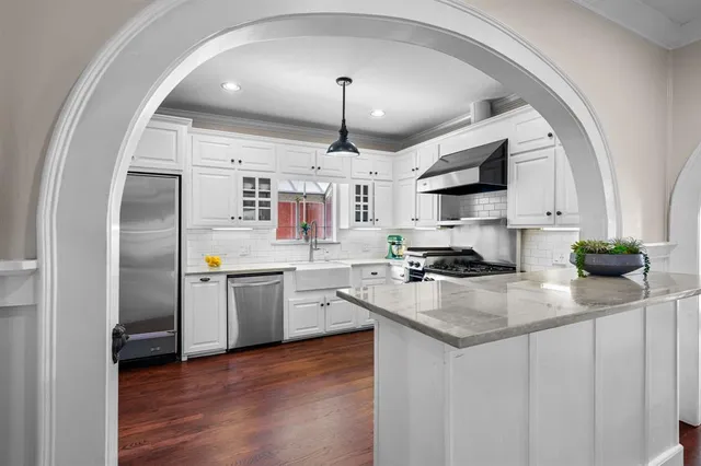 a kitchen with stainless steel appliances a white stove and cabinets